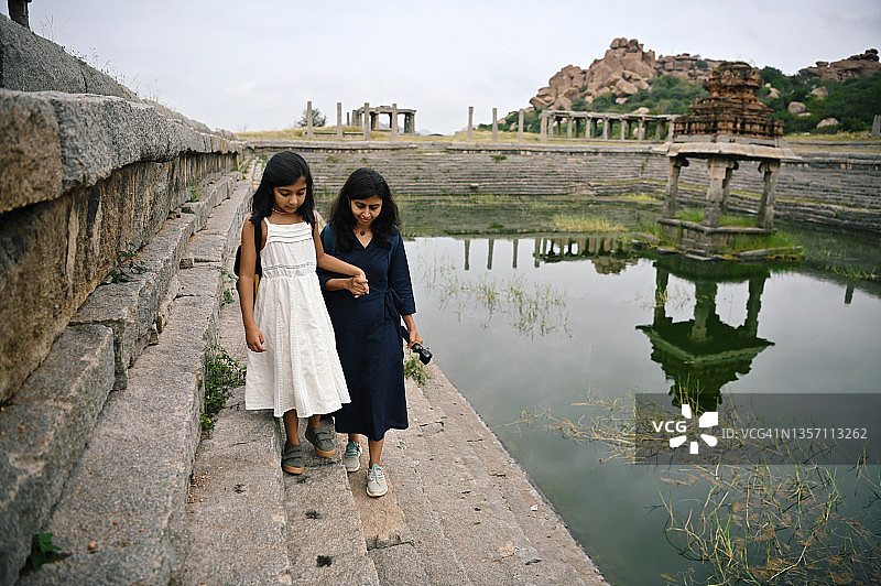 母女在卡纳塔克邦亨比的阶梯井附近散步图片素材