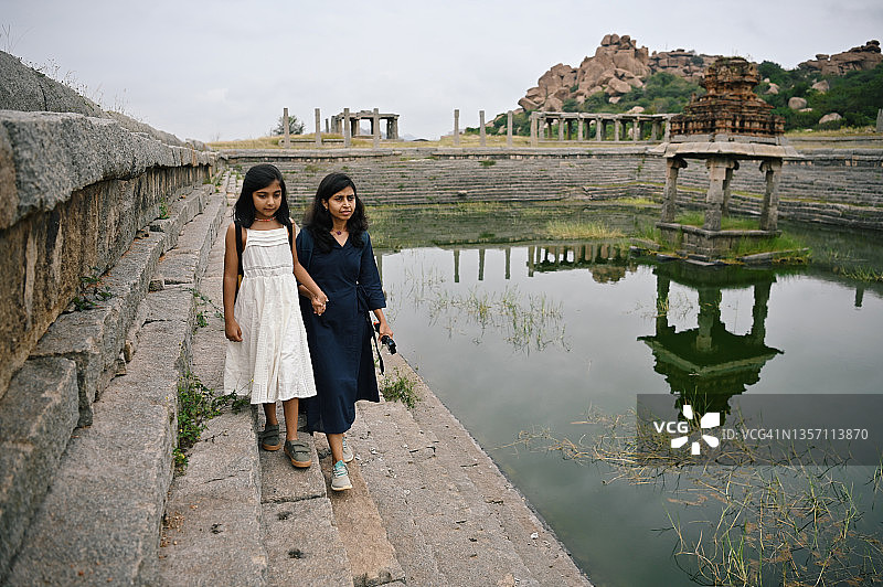 母女在卡纳塔克邦亨比的阶梯井附近散步图片素材