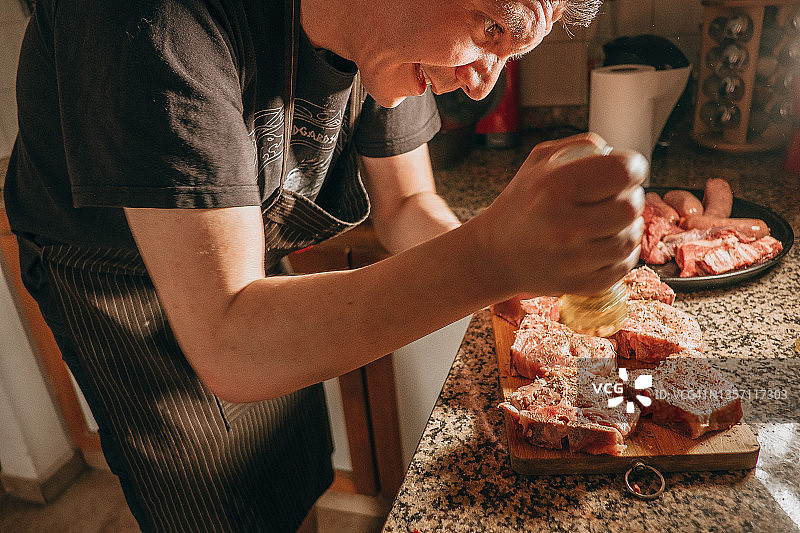 阿根廷男人在木板上给红肉调味图片素材