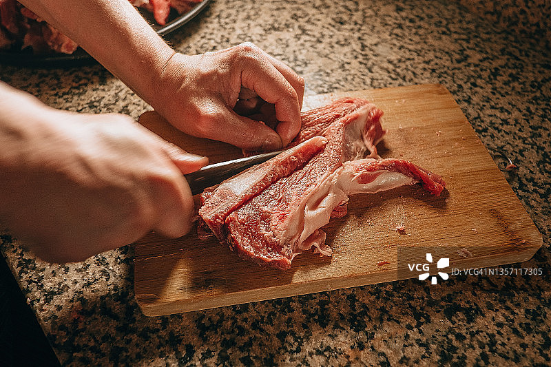 在木板上切割红肉的两只手部特写图片素材