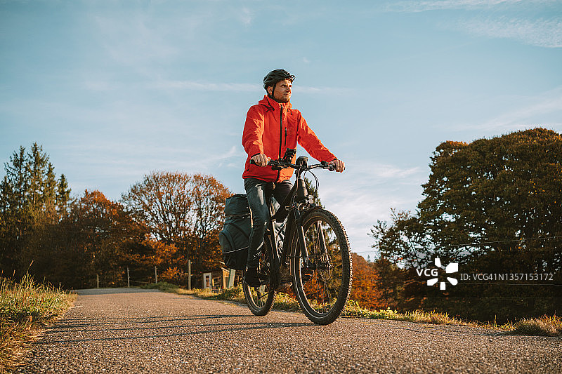 年轻男子骑着电动山地自行车下路图片素材