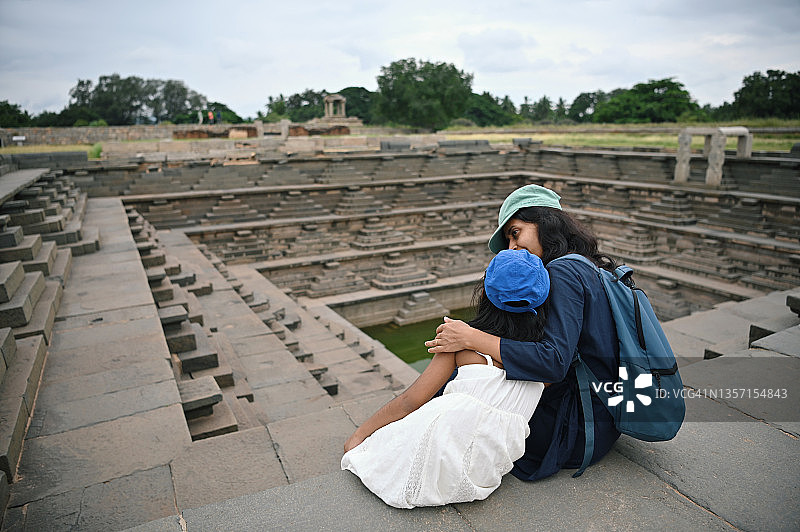 母女站在卡纳塔克邦亨比的阶梯井附近图片素材
