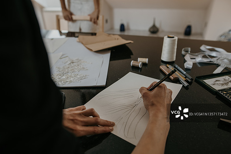 女服装设计师为新款婚纱绘制草图图片素材