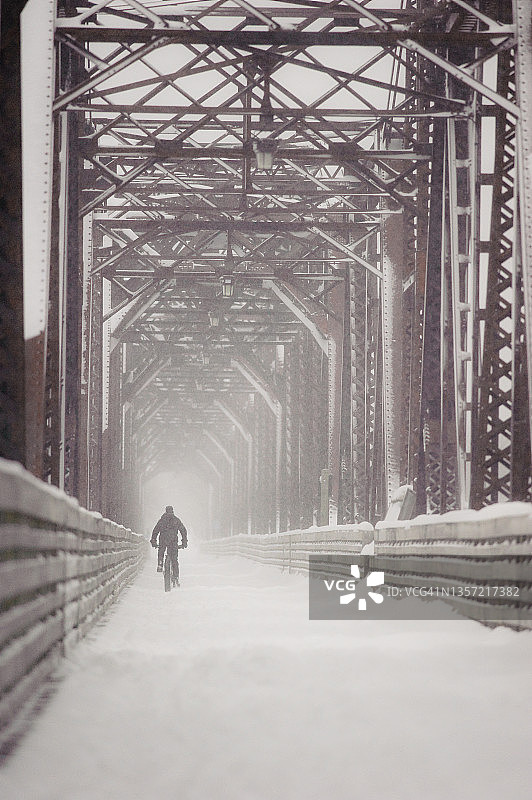 在加拿大新不伦瑞克省弗雷德里克顿的比尔·索普步行桥上冬季骑行图片素材