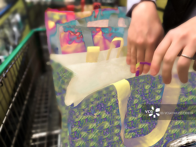 爸爸在收银台付款后将食品装入可重复使用的购物袋图片素材