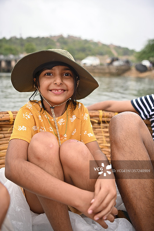 在卡纳塔克邦亨比享受圆形小舟之旅的戴帽子女孩图片素材