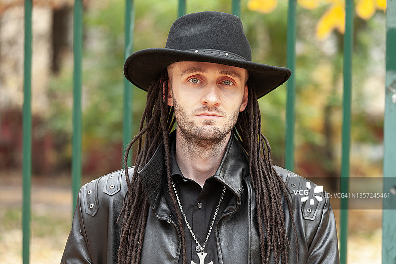 穿着黑色皮衣和帽子的30岁哥特亚文化男人户外肖像特写图片素材