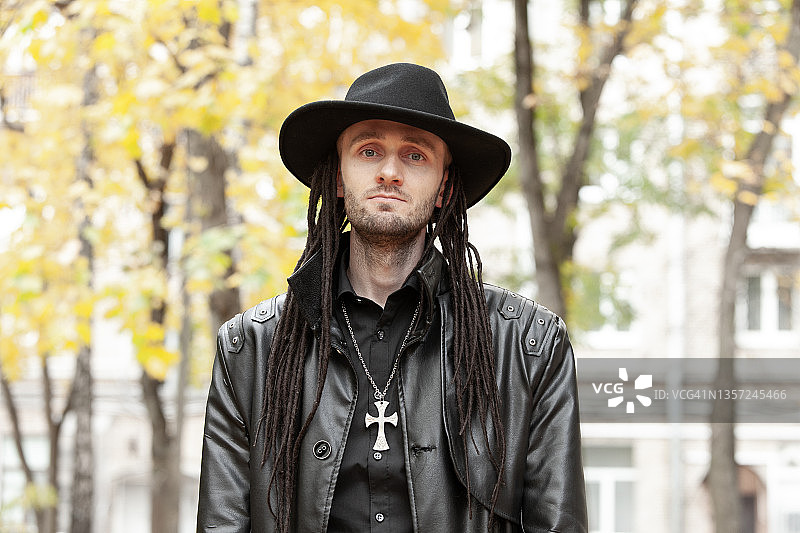 穿着黑色皮衣和帽子的30岁哥特亚文化男人户外肖像特写图片素材