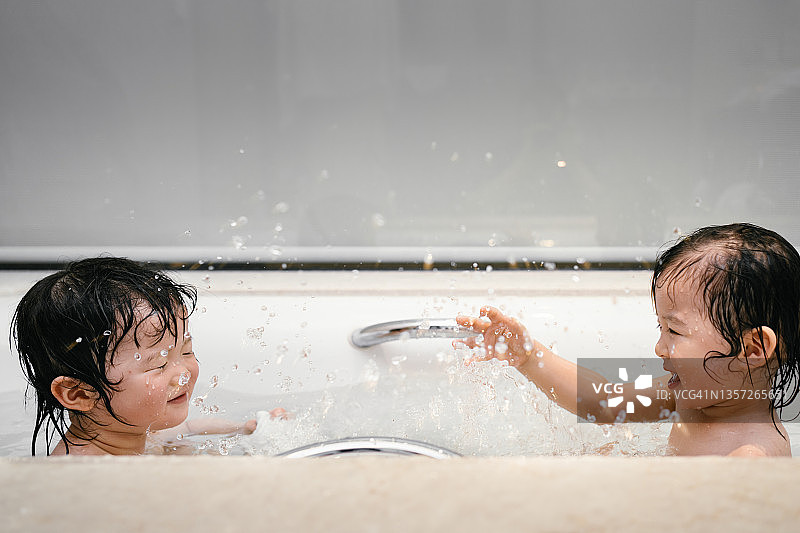 在浴缸里戏水的年轻姐妹图片素材