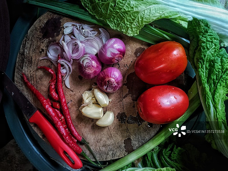 桌上的洋葱、大蒜、西红柿、红辣椒、韭菜和蒜苗切片图片素材