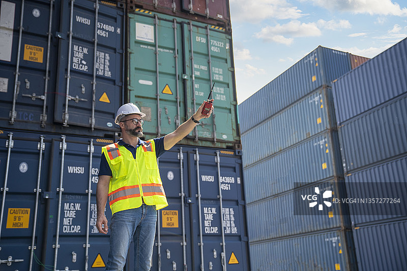 调度员控制从货船装载集装箱，用于进出口图片素材