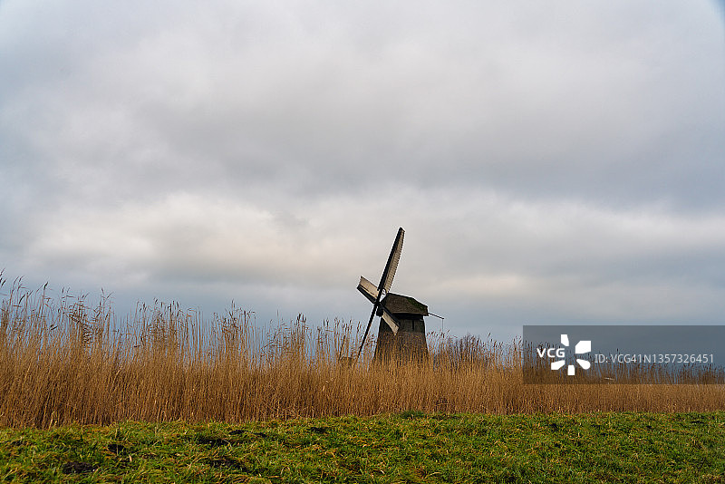 典型的荷兰圩田景观，有风车、云和堤坝图片素材