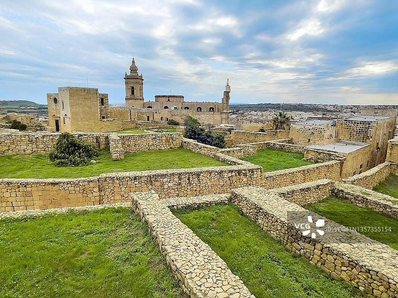戈佐城堡中世纪建筑的历史遗迹，背景为圣约瑟夫教堂和圣玛利亚大教堂，位于马耳他戈佐岛维多利亚图片素材