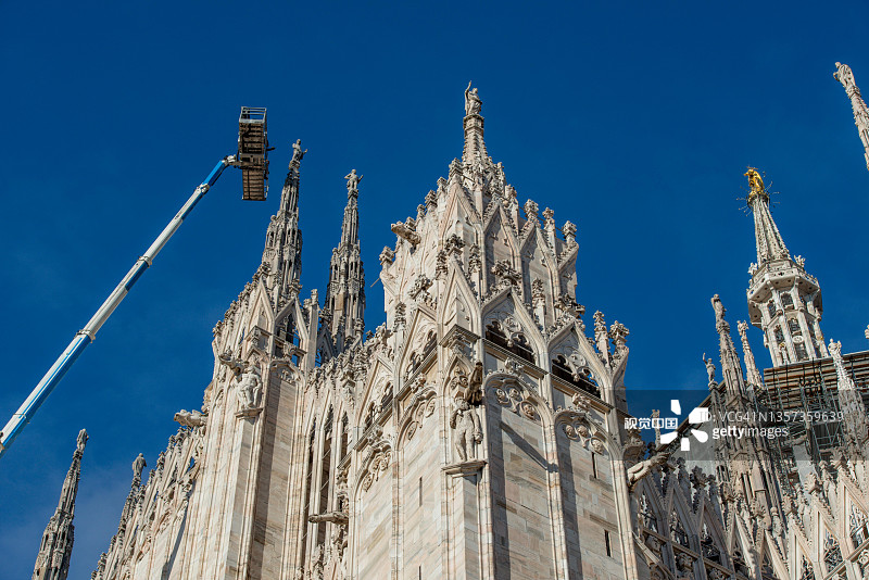 技术人员在升降平台上进行米兰大教堂的维护和研究图片素材