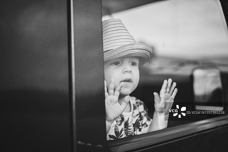 有趣的男孩看着车窗外，快乐的童年图片素材