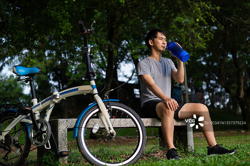 年轻的亚洲男人在公园锻炼后放松图片素材