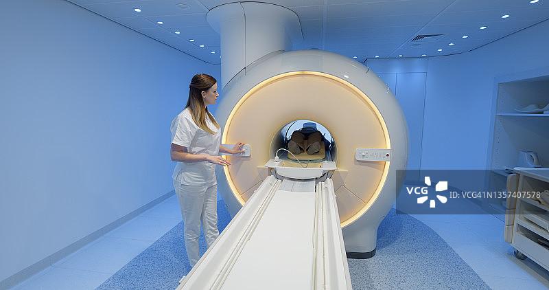 女医生将患者送入MRI扫描仪图片素材