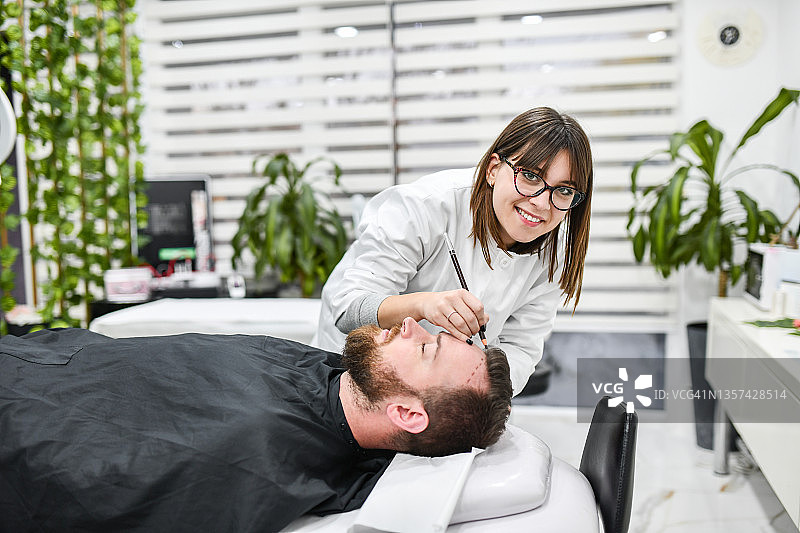 现代诊所内女医生为男病人准备脱发治疗图片素材