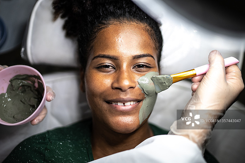 年轻女子在水疗中心做面部护理的肖像图片素材