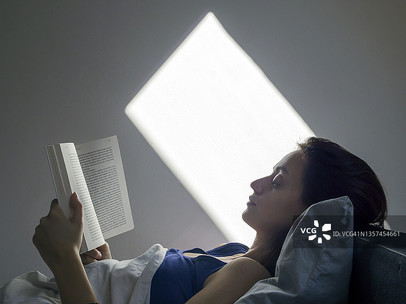 女人在卧室里看书图片素材