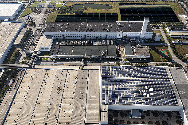 安装在工厂屋顶和停车场的太阳能电池板航拍图图片素材