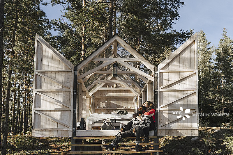 情侣坐在小屋门口拥抱图片素材