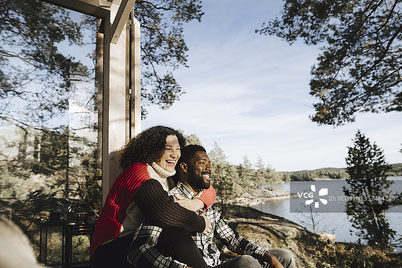 快乐的女人在小屋门口拥抱男友图片素材