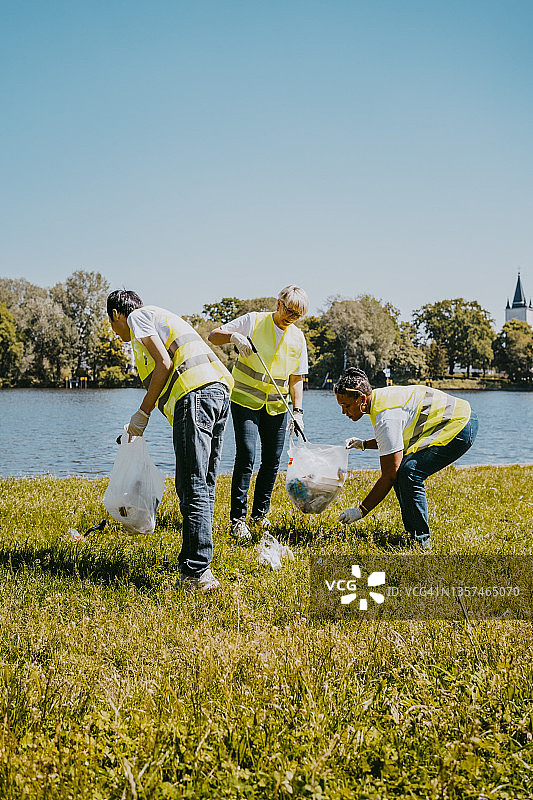 男人和女人在湖边捡拾塑料垃圾图片素材