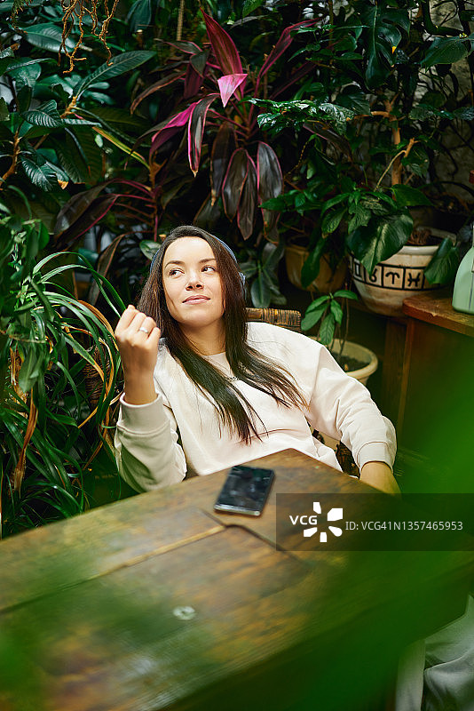 坐在木桌旁的沉思的女人图片素材