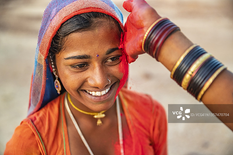 在印度沙漠村庄玩洒红节的印度年轻女孩图片素材