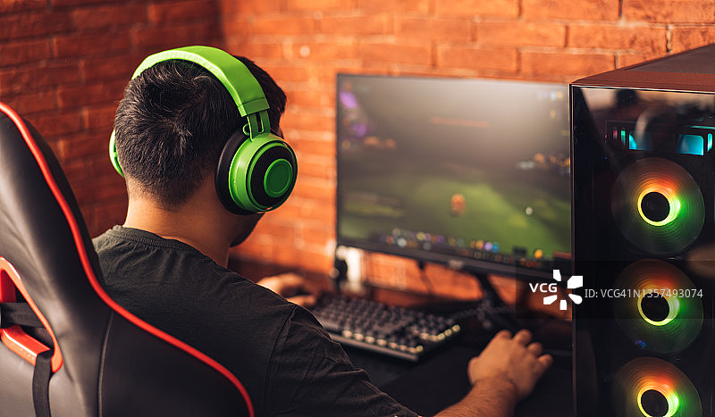 对着砖墙玩电子游戏的男人图片素材