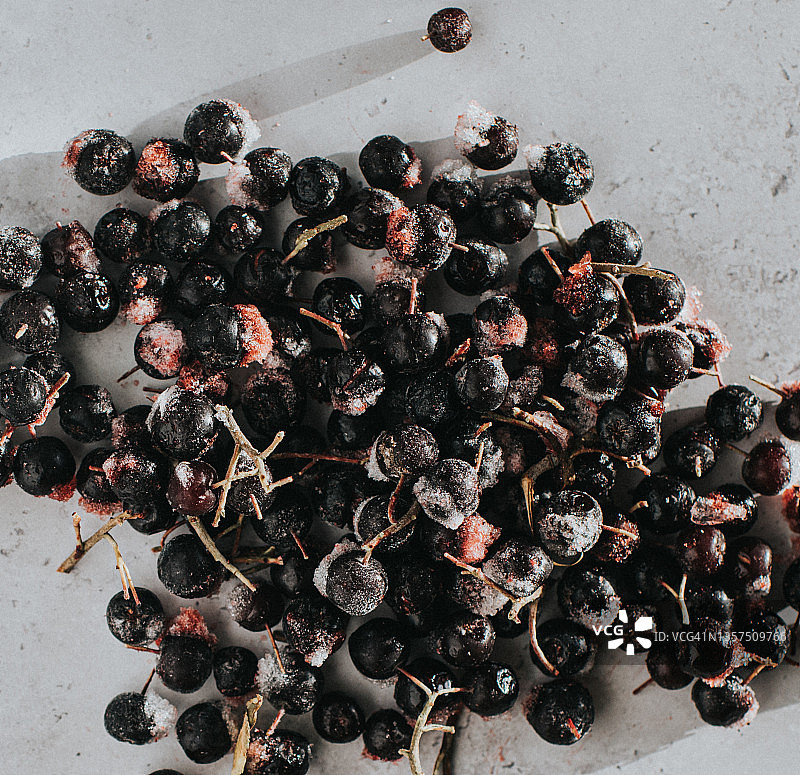白色大理石表面上松散冷冻的黑果腺肋花楸浆果的俯视特写图像图片素材