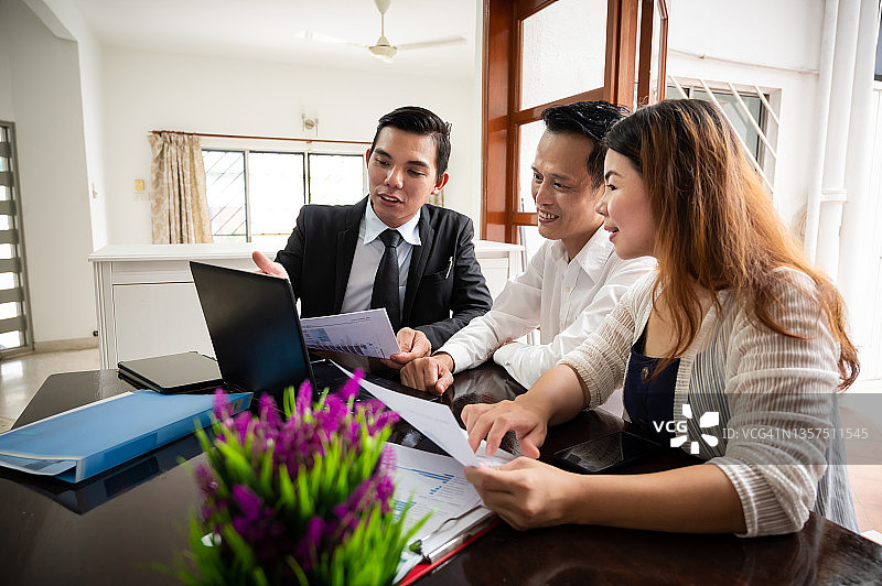 金融顾问进行商务会议，并在家访期间向一对亚洲夫妇提供投资建议图片素材