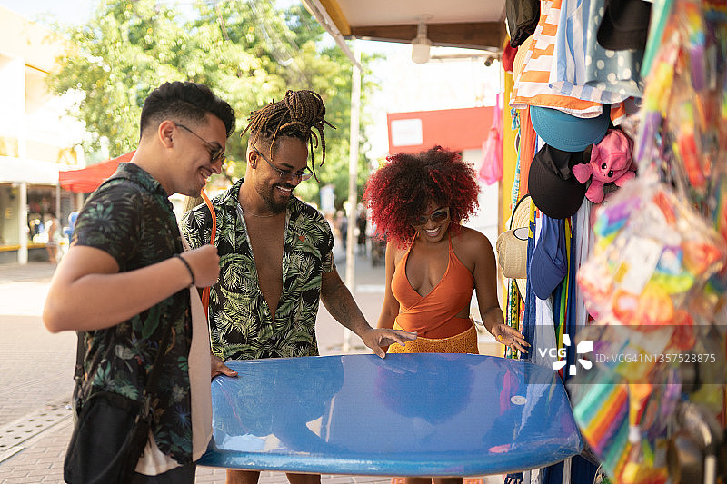 在百货商店购买趴板的冲浪者图片素材