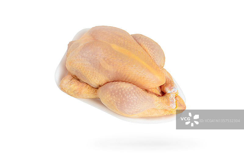 白色背景上的生玉米鸡。鸡胴体装在白色塑料托盘中。黄色肉鸡饲料玉米图片素材