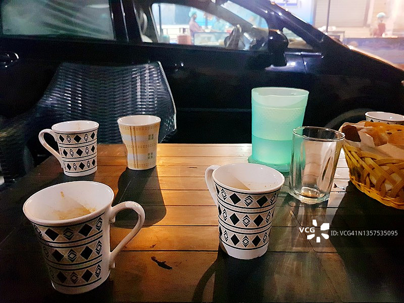 路边木桌上的空咖啡杯或茶杯图片素材