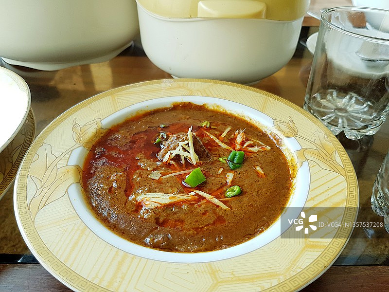尼哈里肉（亚洲和中东的肉类菜肴），配以切碎的姜和青辣椒装饰图片素材