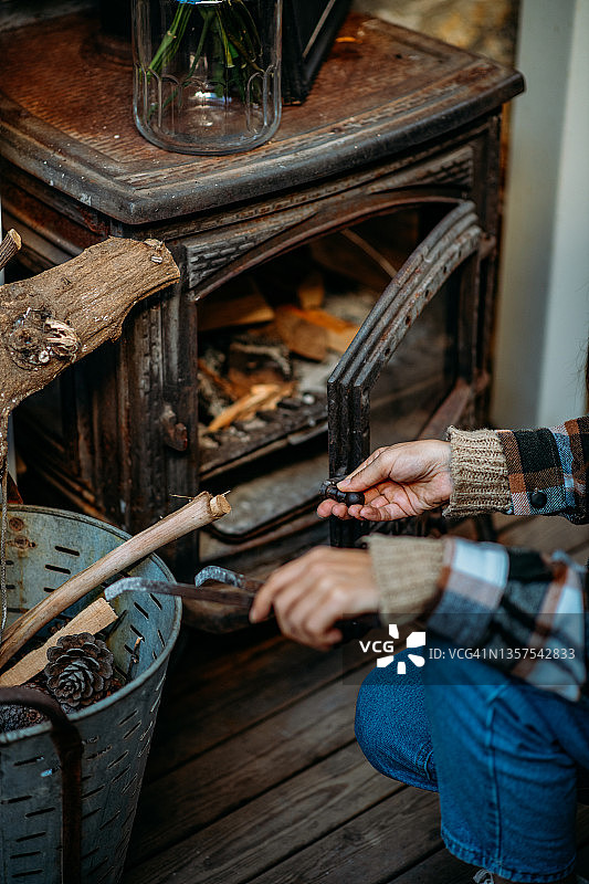 准备点燃柴火炉的年轻女子图片素材