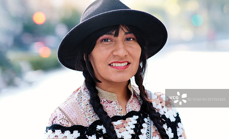 厄瓜多尔妇女的肖像，在户外戴着辫子和黑帽子看着镜头图片素材