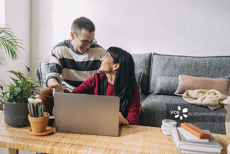 一对夫妇在笔记本电脑上观看节目并交谈图片素材