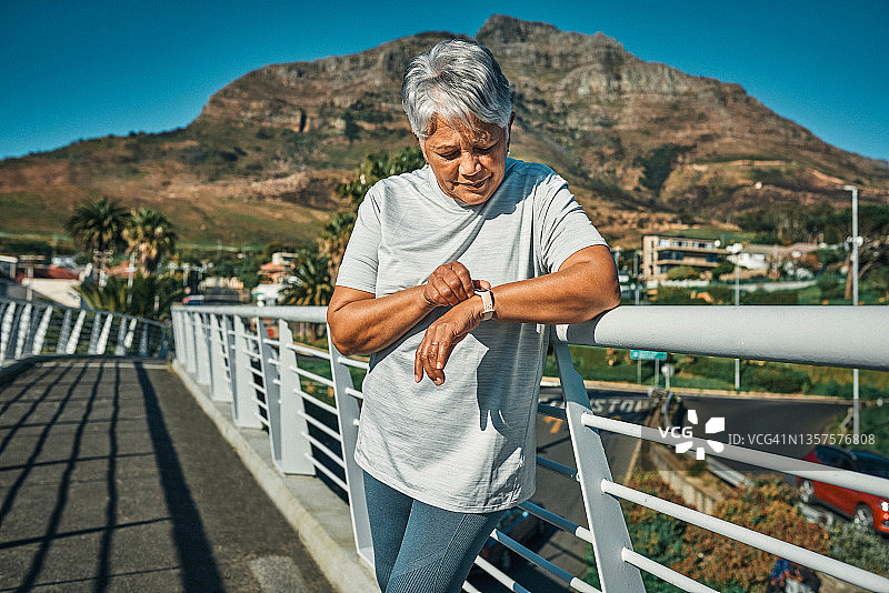 老年妇女在户外独自站立并查看手表图片素材