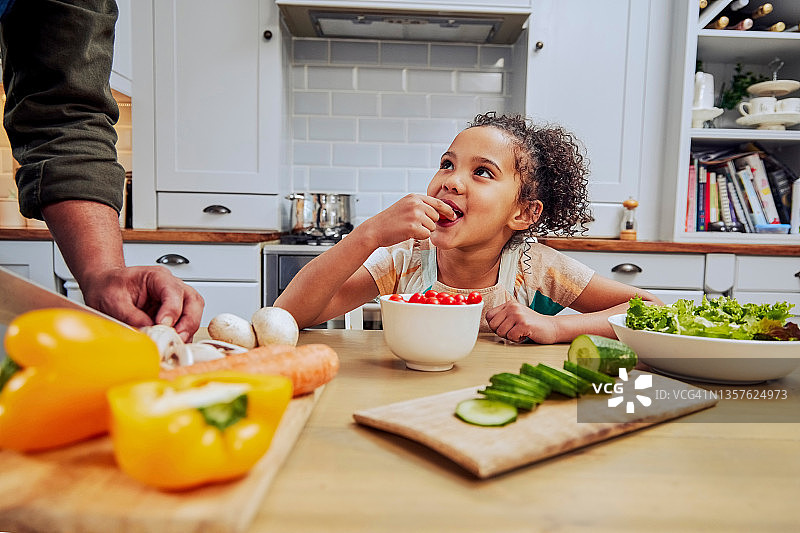 小女孩吃西红柿，父亲教她如何烹饪图片素材
