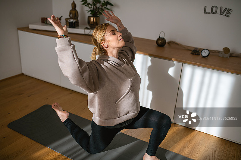 30岁出头的女人在工作室里做弓步的肖像图片素材