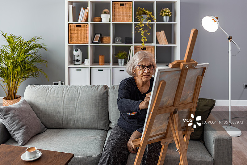年长的女人在画布上绘画图片素材
