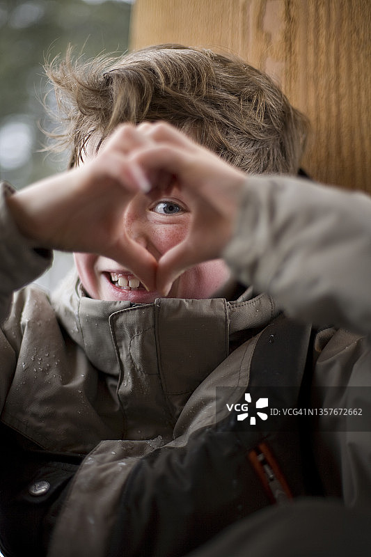 滑雪后透过双手向外看的男孩图片素材