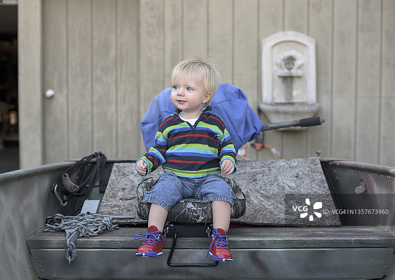 宝宝坐在渔船的船长椅上图片素材