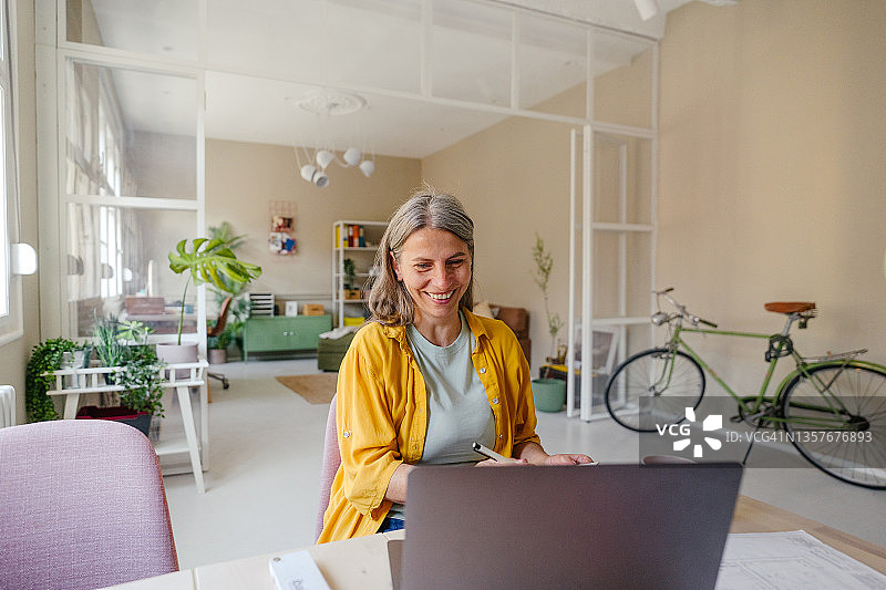 微笑女人在家工作图片素材