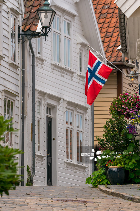 斜坡上带有红色屋顶的美丽白色木屋和小巷排列在狭窄的街道上图片素材