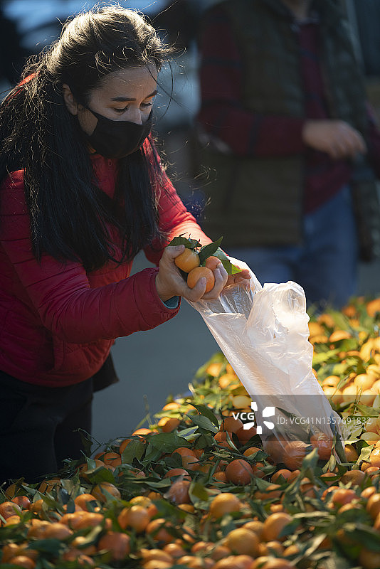 戴防护口罩的女人在农贸市场购物的照片图片素材