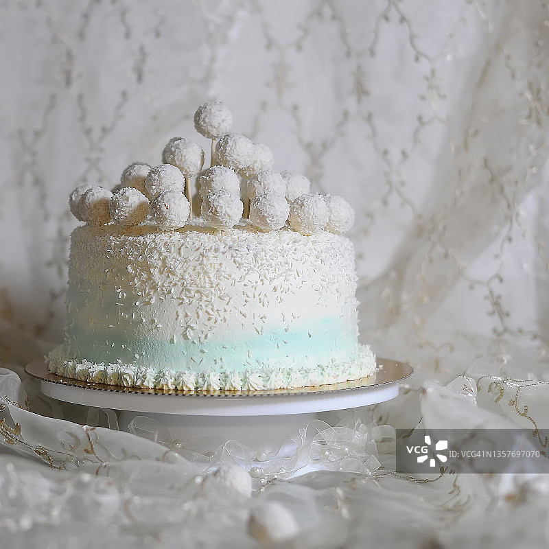 白色椰子蛋糕美食摄影，浅色纺织背景特写图片素材